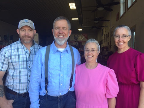 Two men and two women standing in a row.