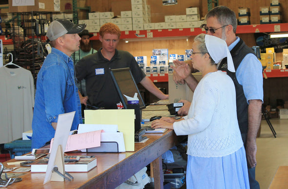 Woman and man checking out a customer at the register